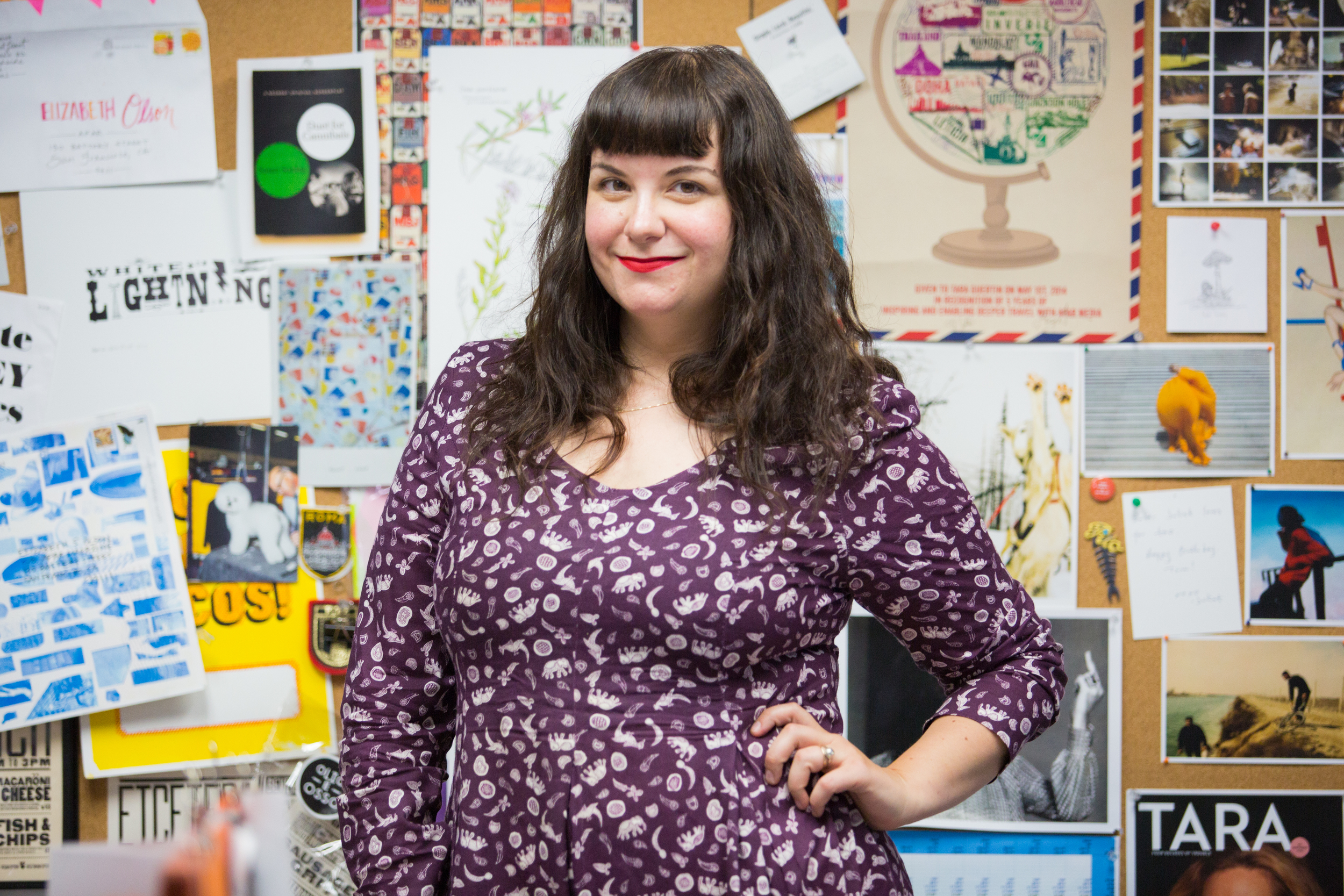   Elizabeth in front of her office mood board.&nbsp;  