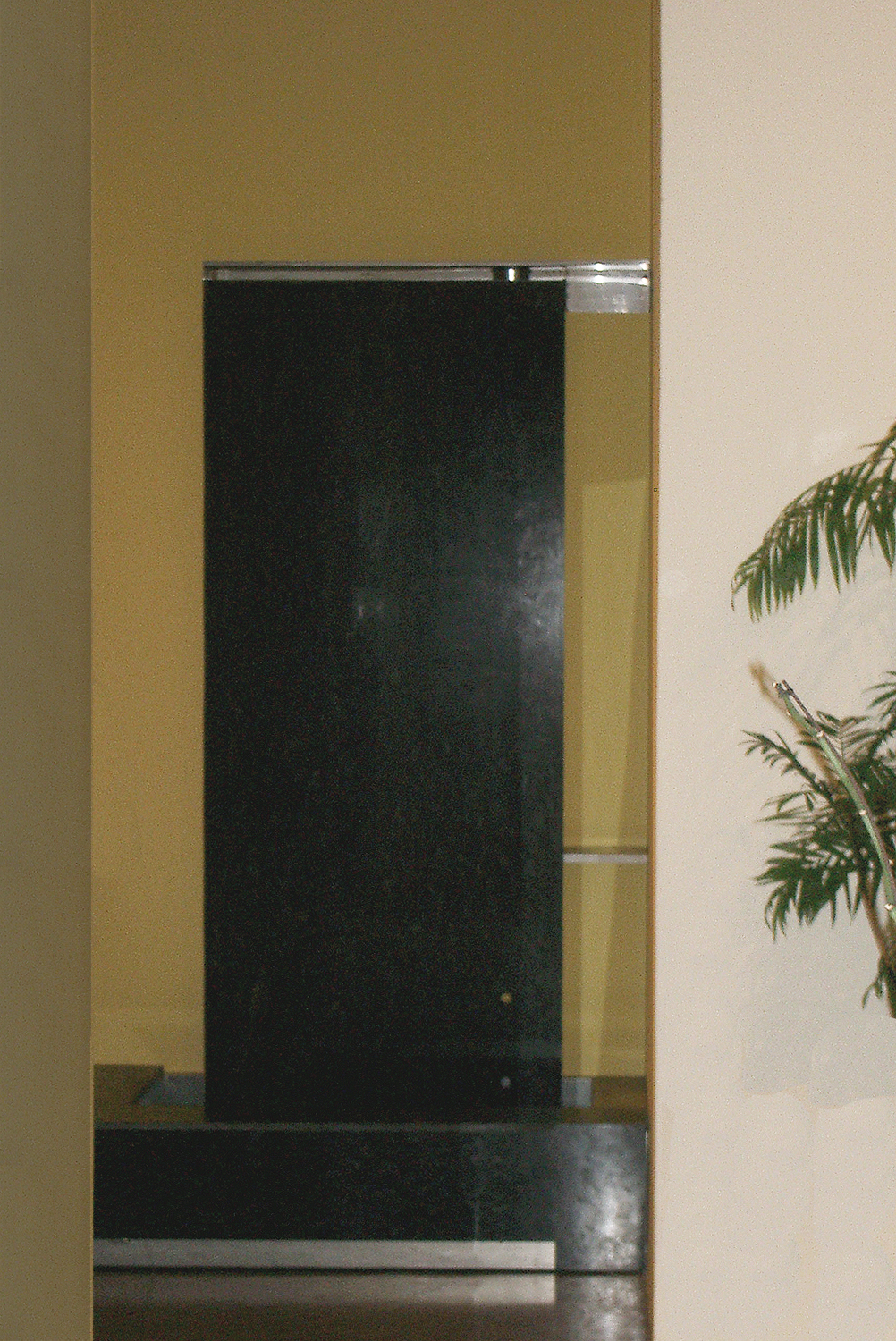 A fountain was designed with stainless steel and a 9 foot slab of granite. The fountain creates a sense of calm from the city outside.