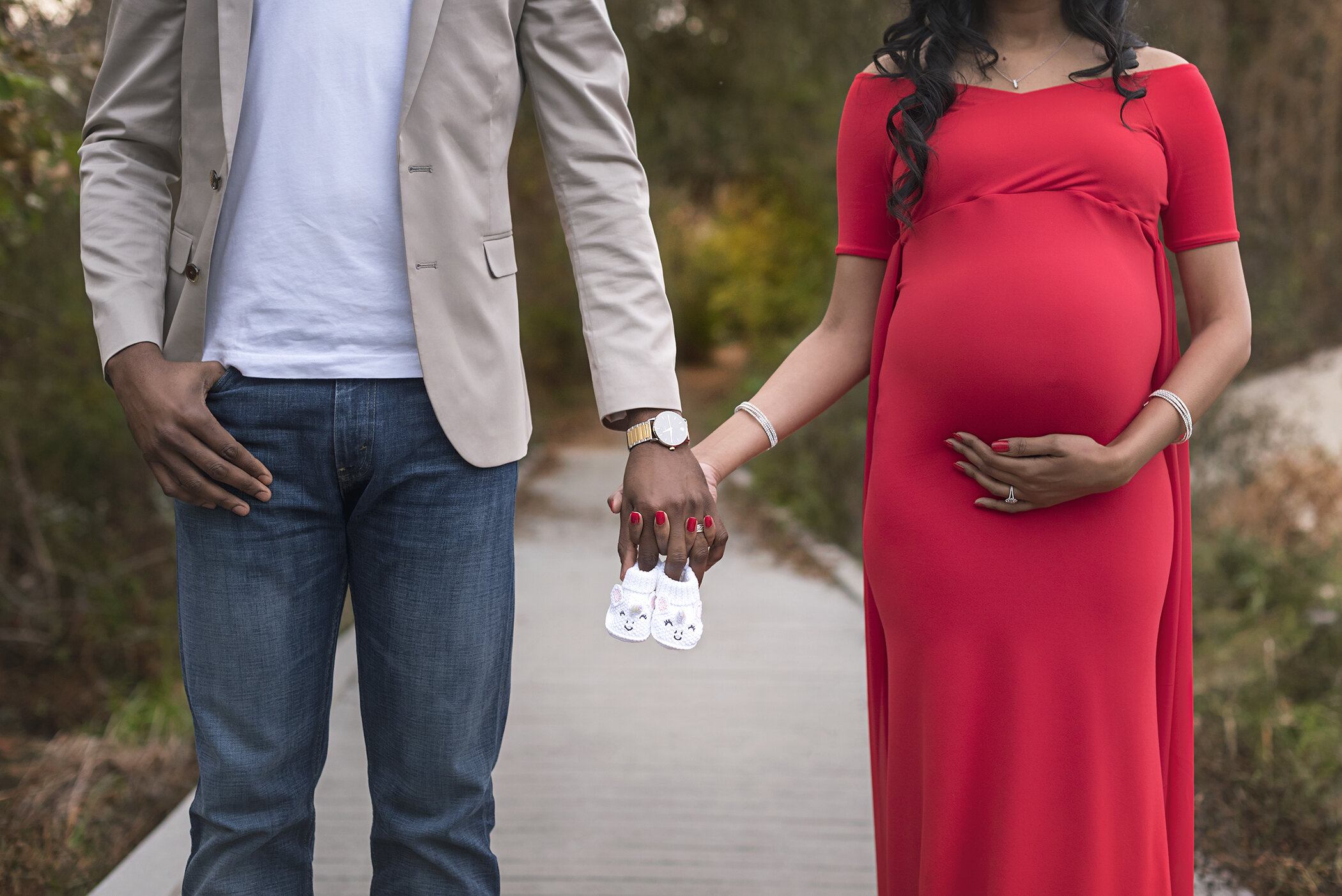 maternity couple with baby shoes