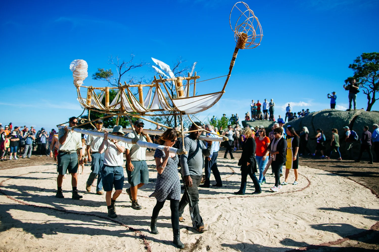 Parks Victoria and Canoe artists Leonard Tebegetu and Mahony Kiely carrying Canoe through the first walking circle at the conclusion of The Gathering of the Elders ceremony.  Image by Ed Sloane Photography