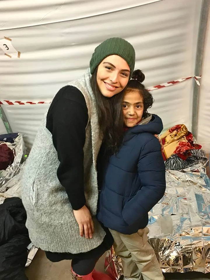 Photo: Aziza and Shams, a Syrian refugee. at a medical clinic inside of a tent at the Moria Refugee camp where Shams' younger sibling was being treated.