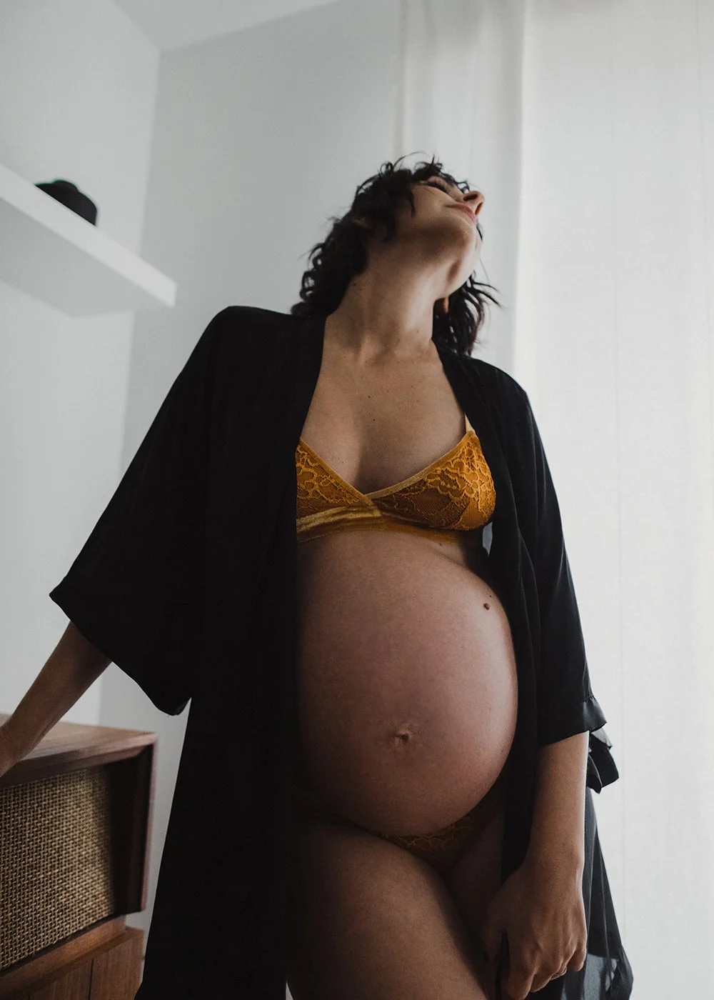 woman showing pregnancy wearing bra and robe