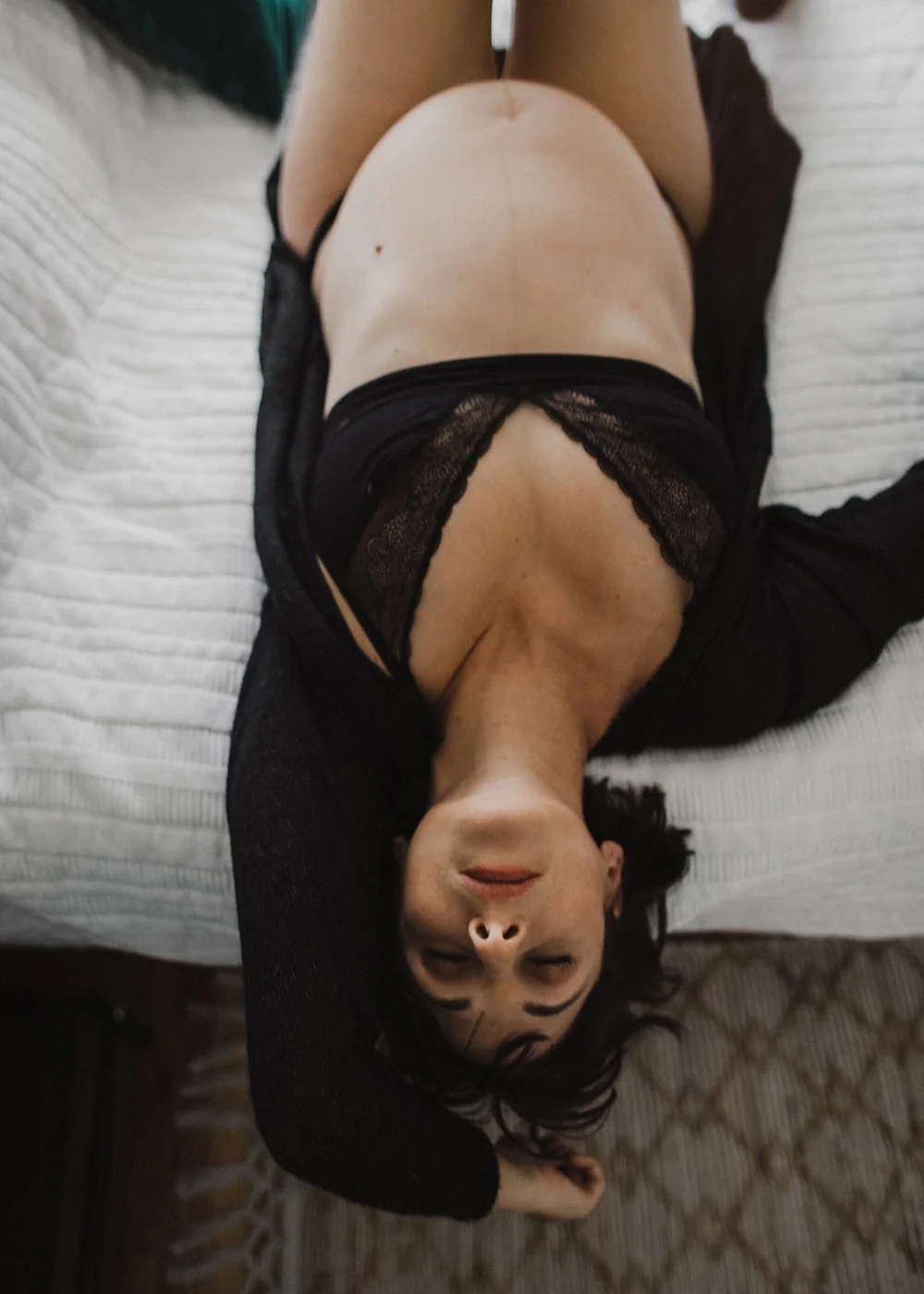 pregnant woman lying on bed with neck bent backwards