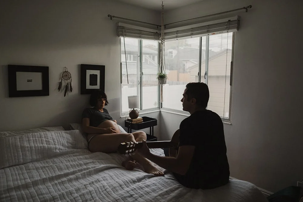 man playing guitar while staring at wife