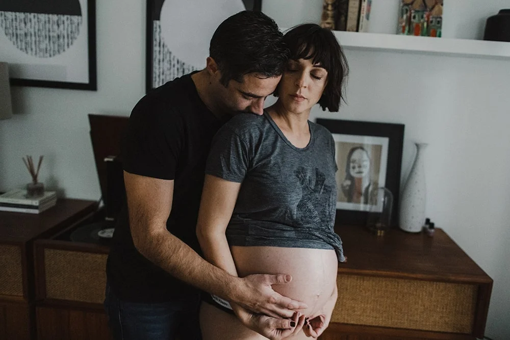 couple touching noses while man grab's womans stomach