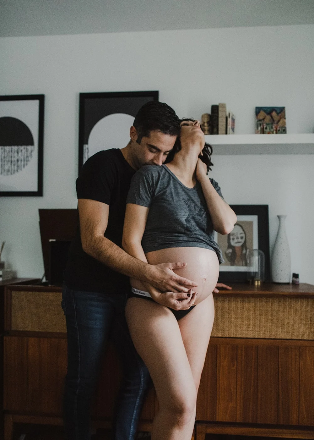 man kissing wife's shoulder while she is in pregnancy