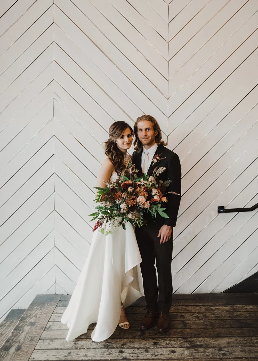 bride and groom smiling at camera with bouquet