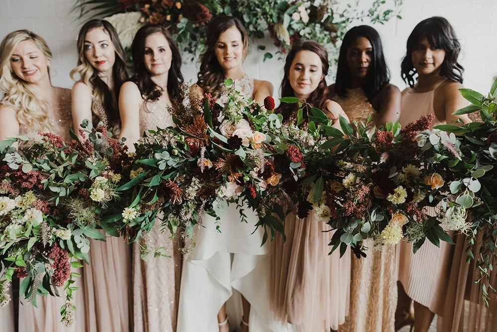 Bridesmaids holding bouquets toward camera