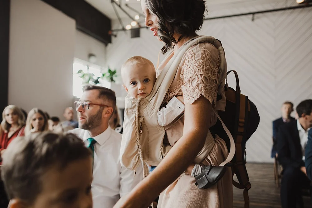 baby looking at camera while mother holds him