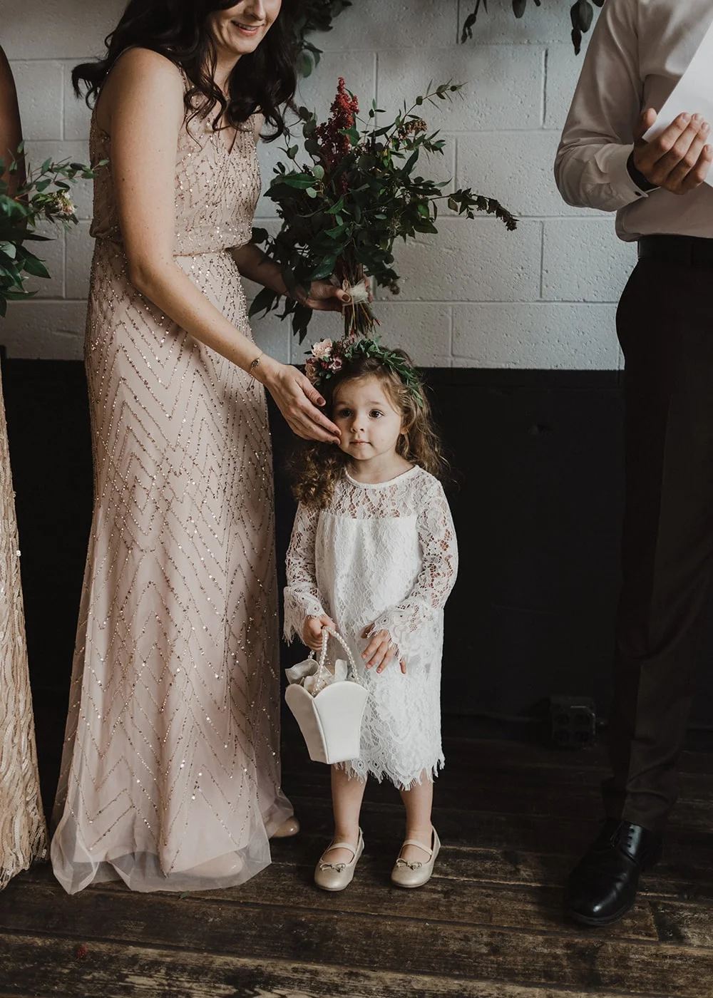 little flower girl with mother holding her cheek