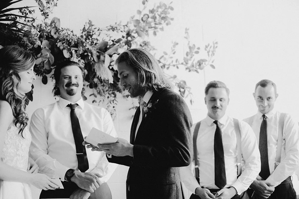 groom reading his vows in black and white photo