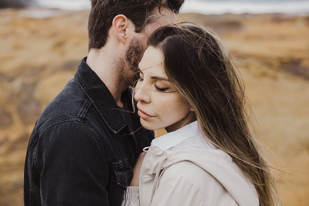 woman snuggling up to man while he holds her