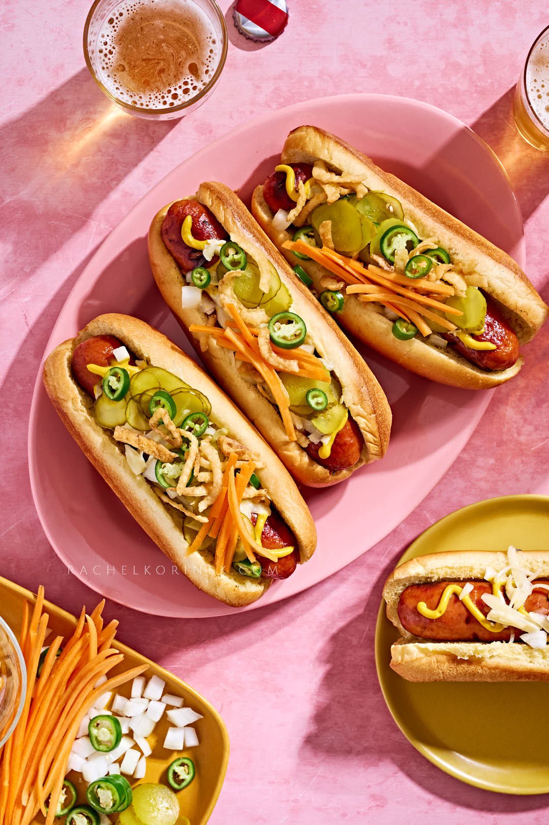  Hot dogs and beer on a bright pink backdrop. 