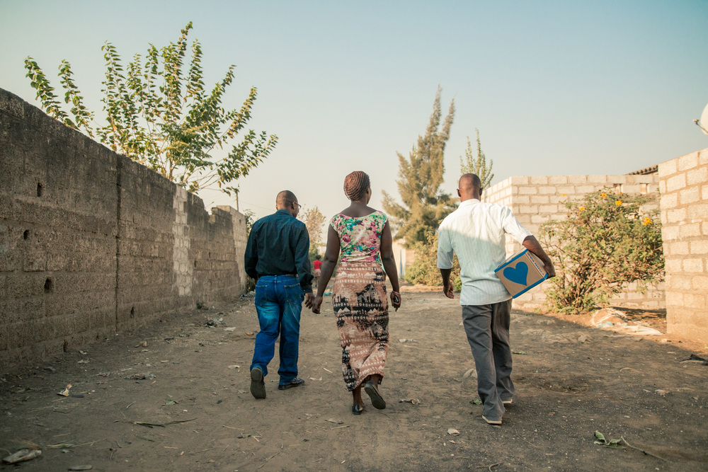  ZAMBIA: [Home Visit] Pastor German and friends walking through John Laing to deliver the first Food Pak. 