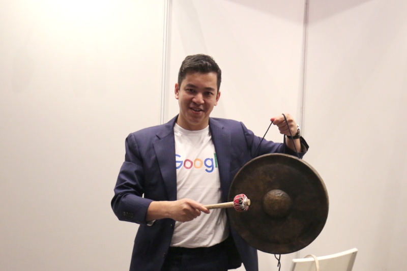Emcee Ben Ibrahim posing with Gapture's gong
