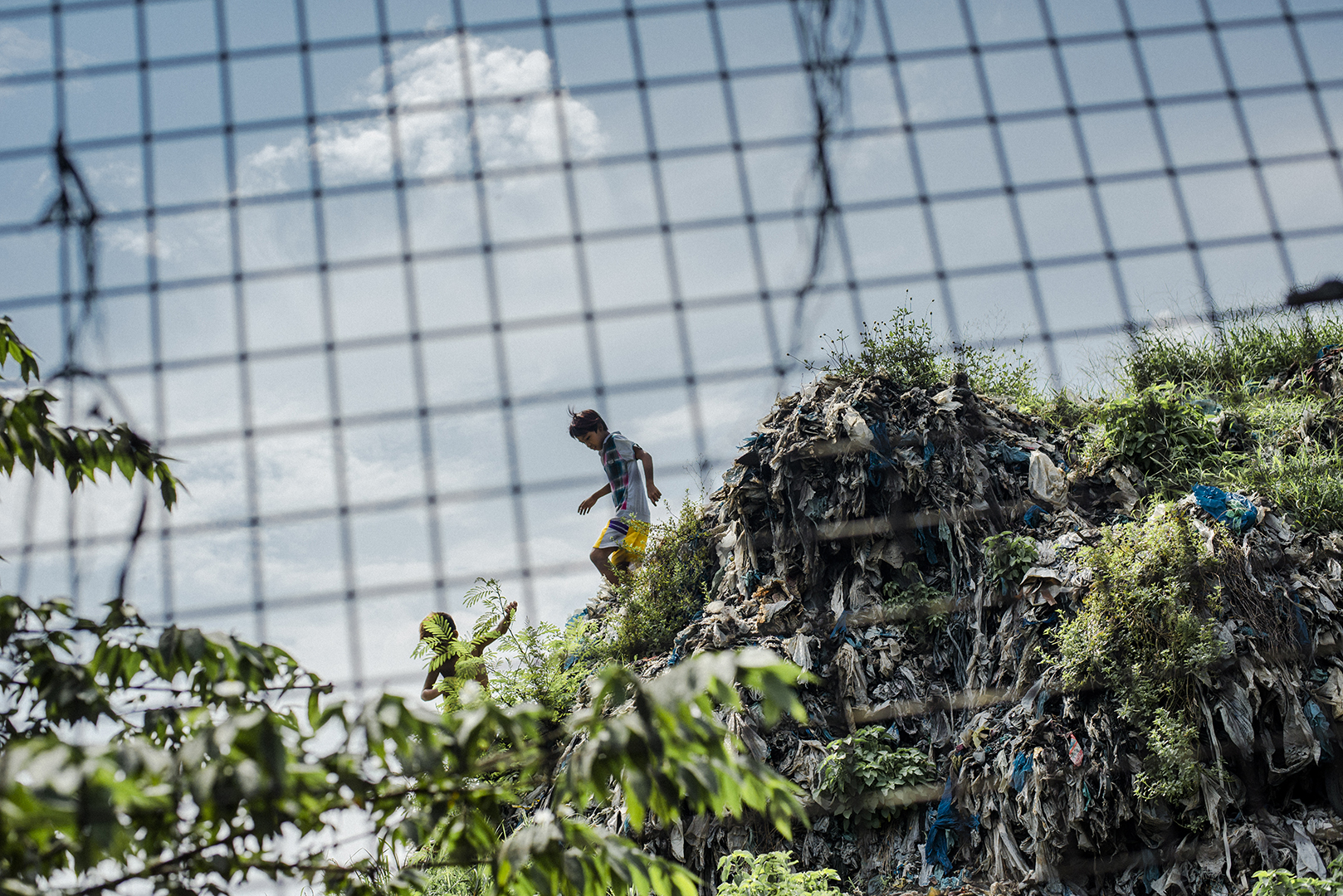 Charcoal production community is located directly beside a dumpsite garbage mountain, a part of the remains of the famous “Smokey Mountain” slum area, where over two million metric tons of Manila’s waste were stocked for more than 40 years. The resettlement residences provided by the Philippines’ Government for more than 30.000 people who used to live there, were built in remote areas where little facilities are provided. As a result, most still live in the slums around Tondo and Malabon. Metro Manila garbage is currently stocked on an abandoned island not far from the shore and the port area in Payatas still stays a main place for scavengers to work. Malabon, Philippines, 2017
