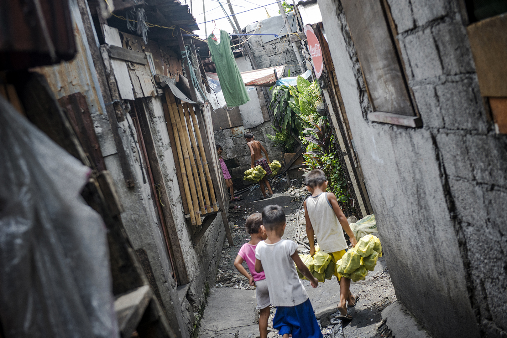 Kids in the community start helping their parents from a very early age. The youngest to be paid for their work are about 7- 8 years old, but even earlier kids help their older siblings and parents, they live in the area and are constantly exposed to the toxic smoke. Malabon, Philippines, 2017