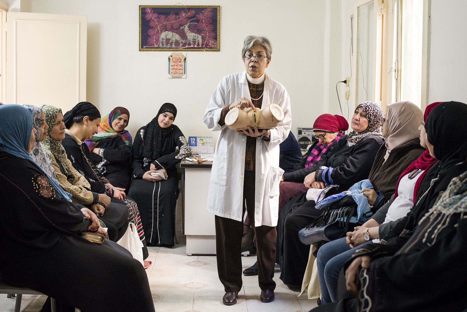 Dr. Mawaheb al Mowelhy is giving a seminar on the negative consequences of Female Genital Mutilation to the women gathered in a clinic located in an urban poor community in Cairo.The gynaecologist, after completing her PHD in Harvard, came back to Egypt where since 1994 she fights against the practice of female circumcision. Despite the criminalisation of the procedure and connected efforts of authorities, NGOs and even religious leaders, in some areas up to 80% of women are still being circumcised. After several cases of deaths of young girls after unsafe procedures, FGM has recently been mostly provided by medical practitioners who financially benefit from the situation. December 2018, Cairo, Egypt