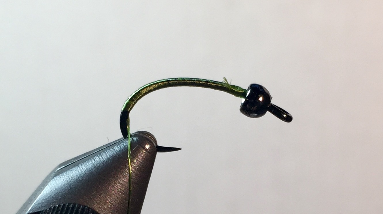 Step 1: Slide bead on hook and place in vise. Start thread behind bead and wrap half down the bend.