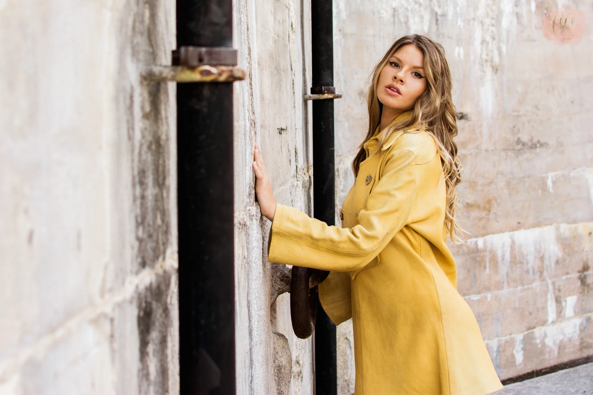 Fashion photography of model in yellow jacket at St. Petersburg beach fort by Carlie Chew Photography 