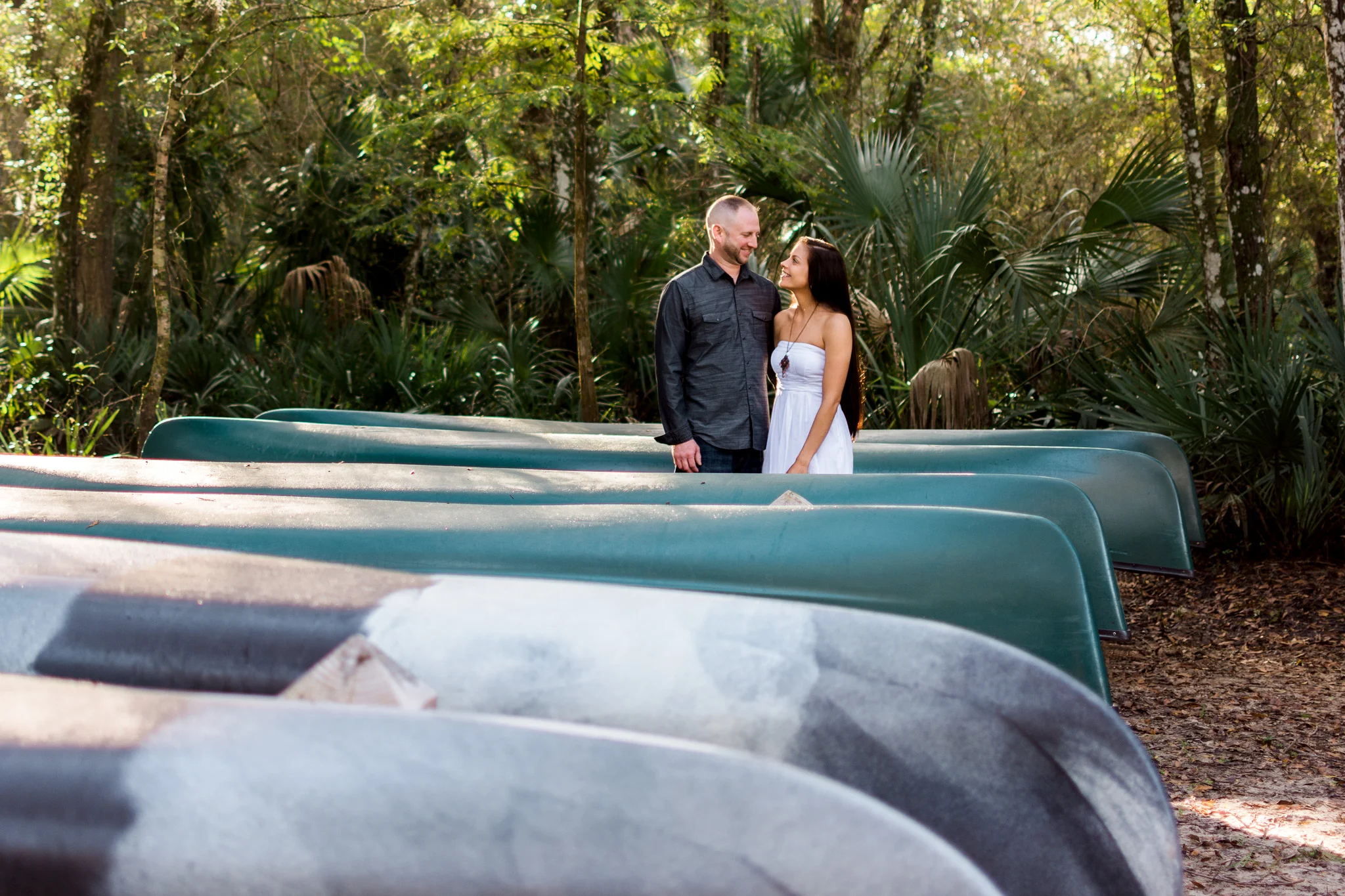 Carlie Chew Photography captures loving couples portrait surrounded by kayaks at Lettuce Lake Park, Tampa, Florida 