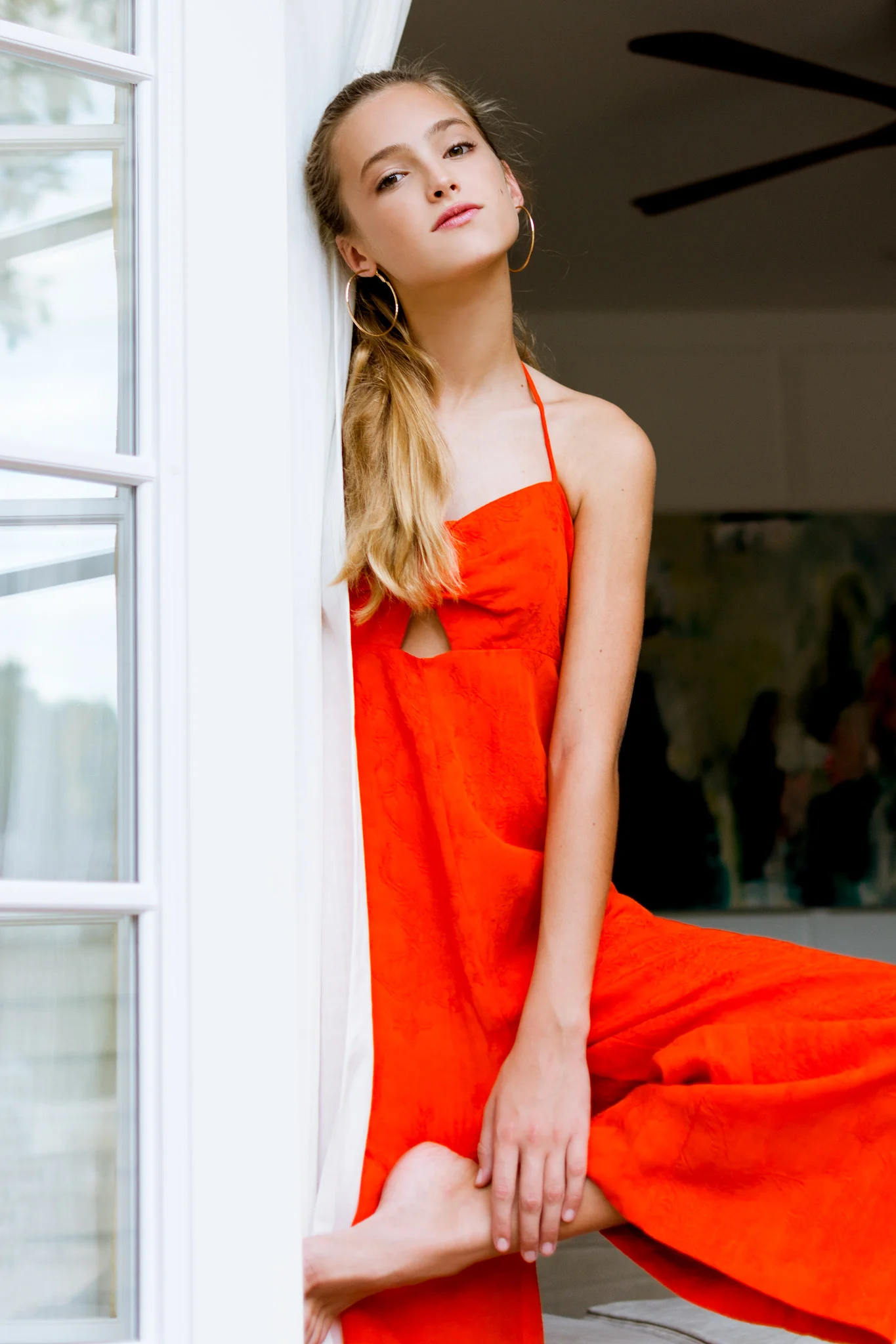 Model poses causal in red Anthrpologie Elevenses jumpsuit, photographed by Carlie Chew in Tampa, Florida 