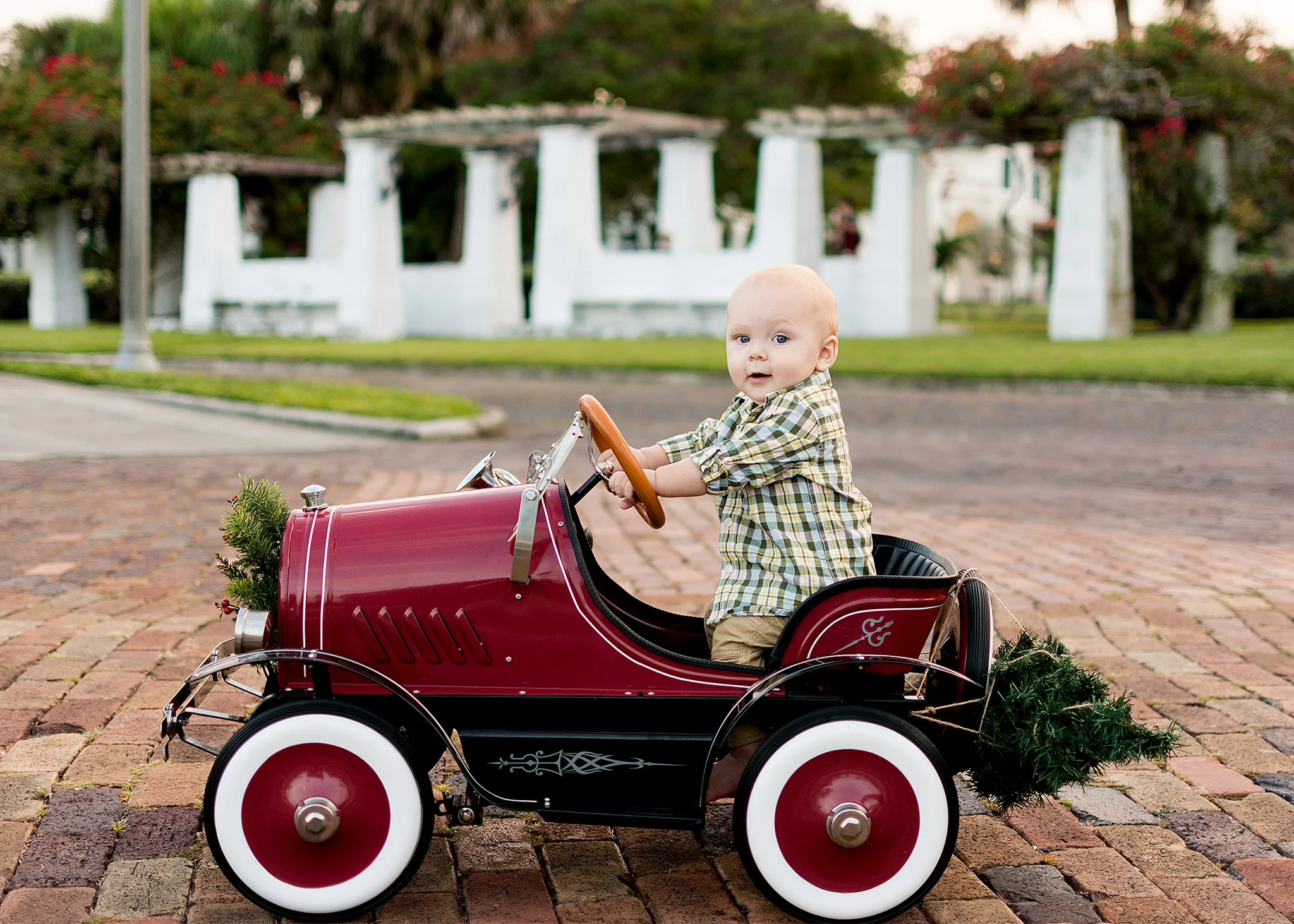 Baby boy in vintage red car with Christmas tree for holiday photos with Carlie Chew Photography in St. Petersburg FL