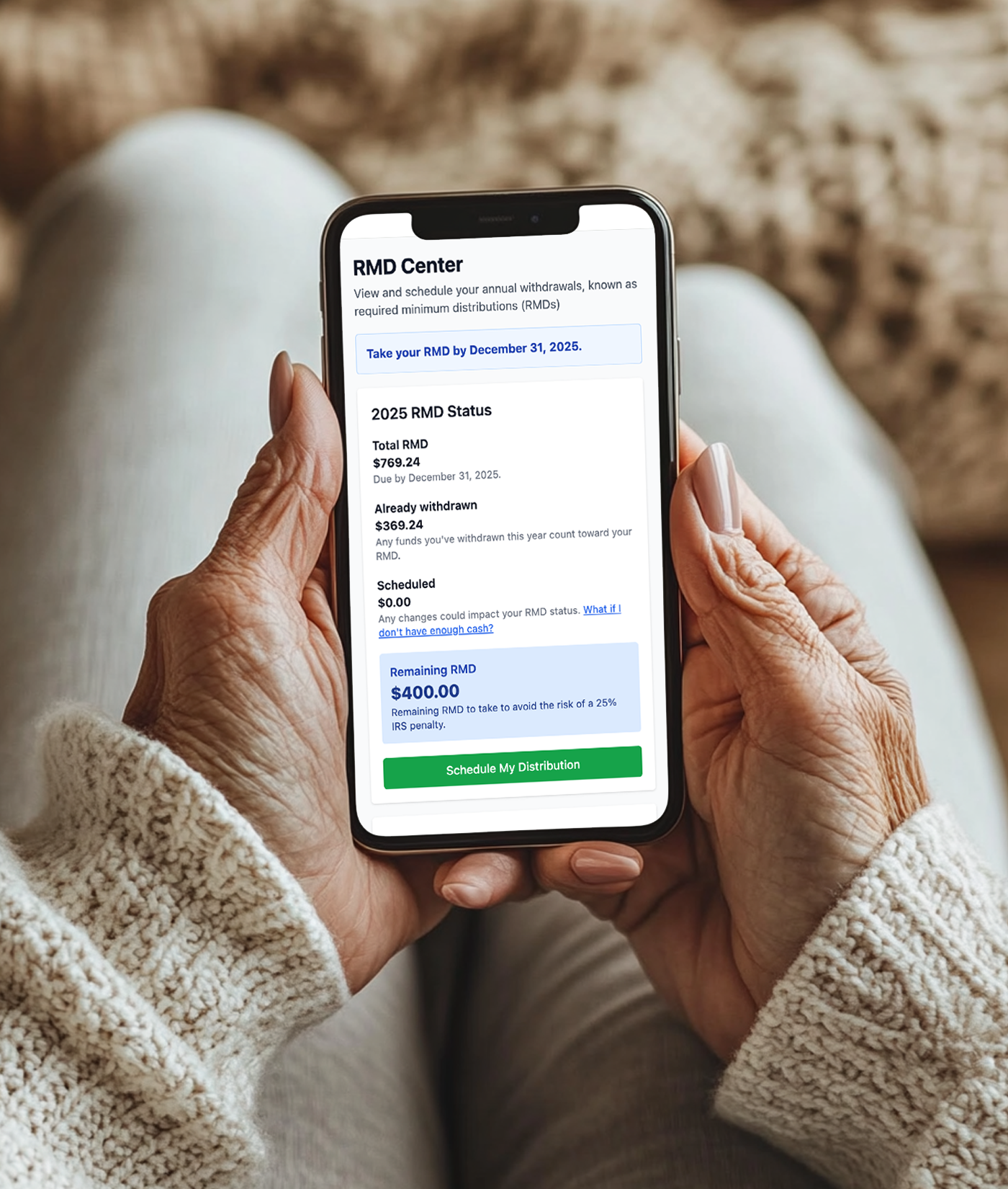 Close-up of an elderly person holding a smartphone displaying a financial app with details about required minimum distributions (RMDs).