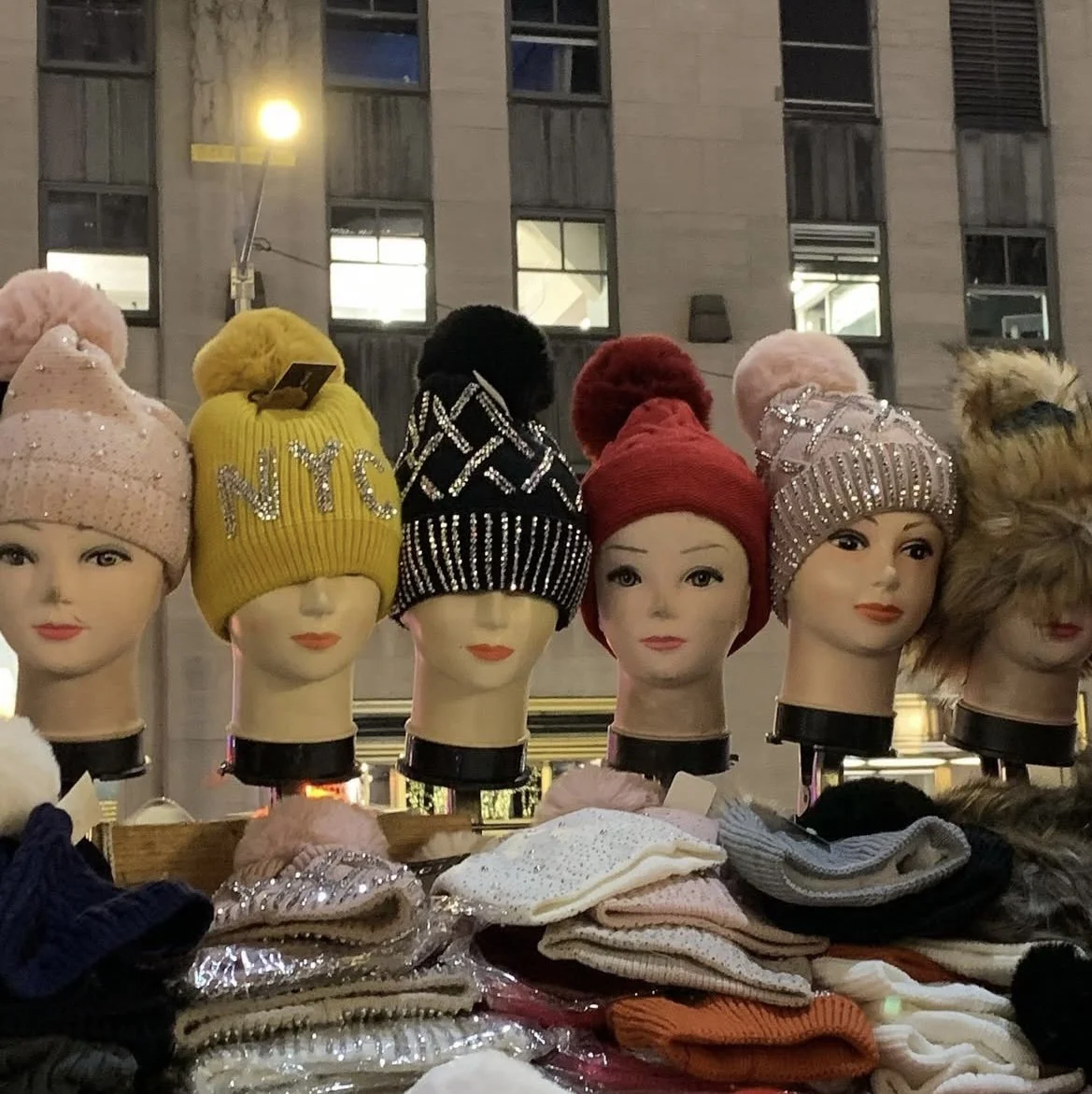 A Chorus of Hats: Mom always said, keep your head warm. New York answers with a chorus of hats—street style at its best. Times Square Hat Vendor.