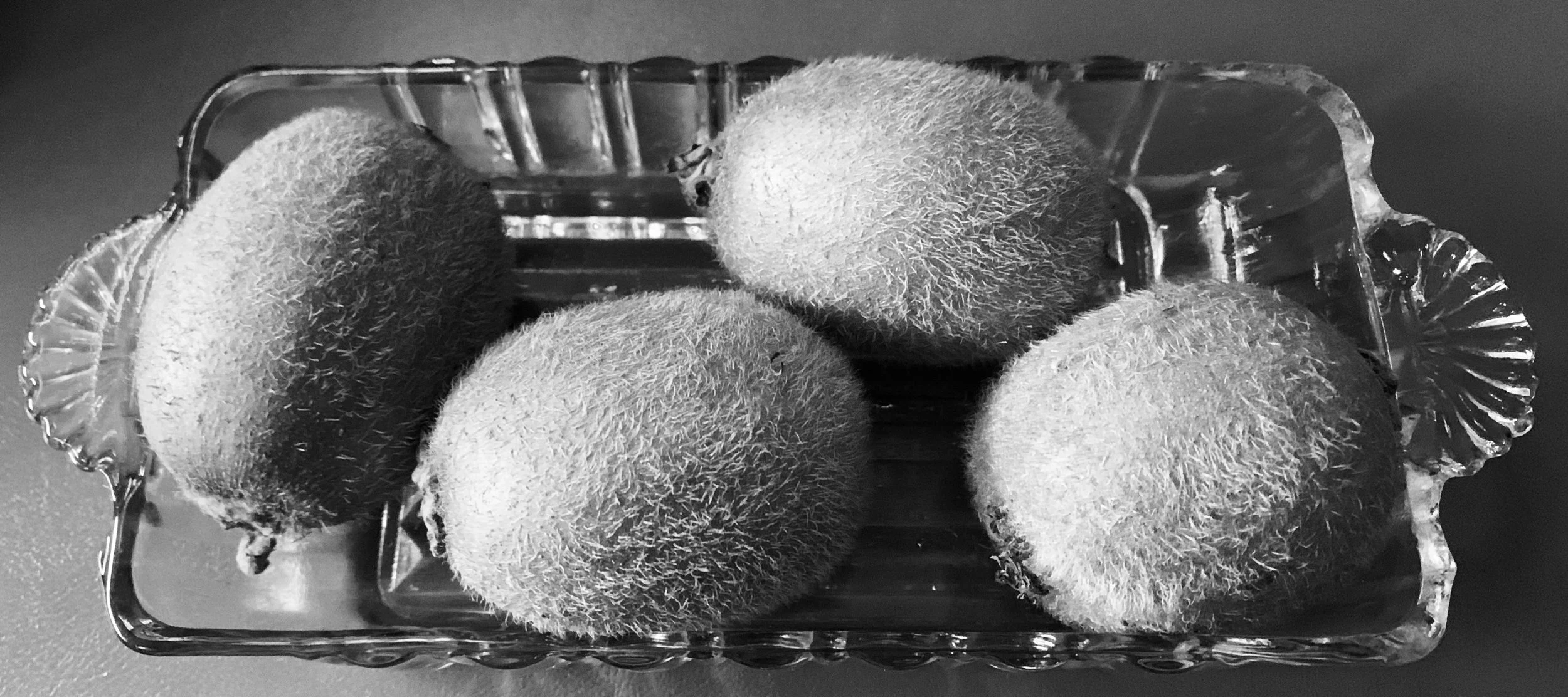 Four Kiwi in Grandma’s Glass Dish: memory, inherited objects, and quiet love rendered in black and white. 
