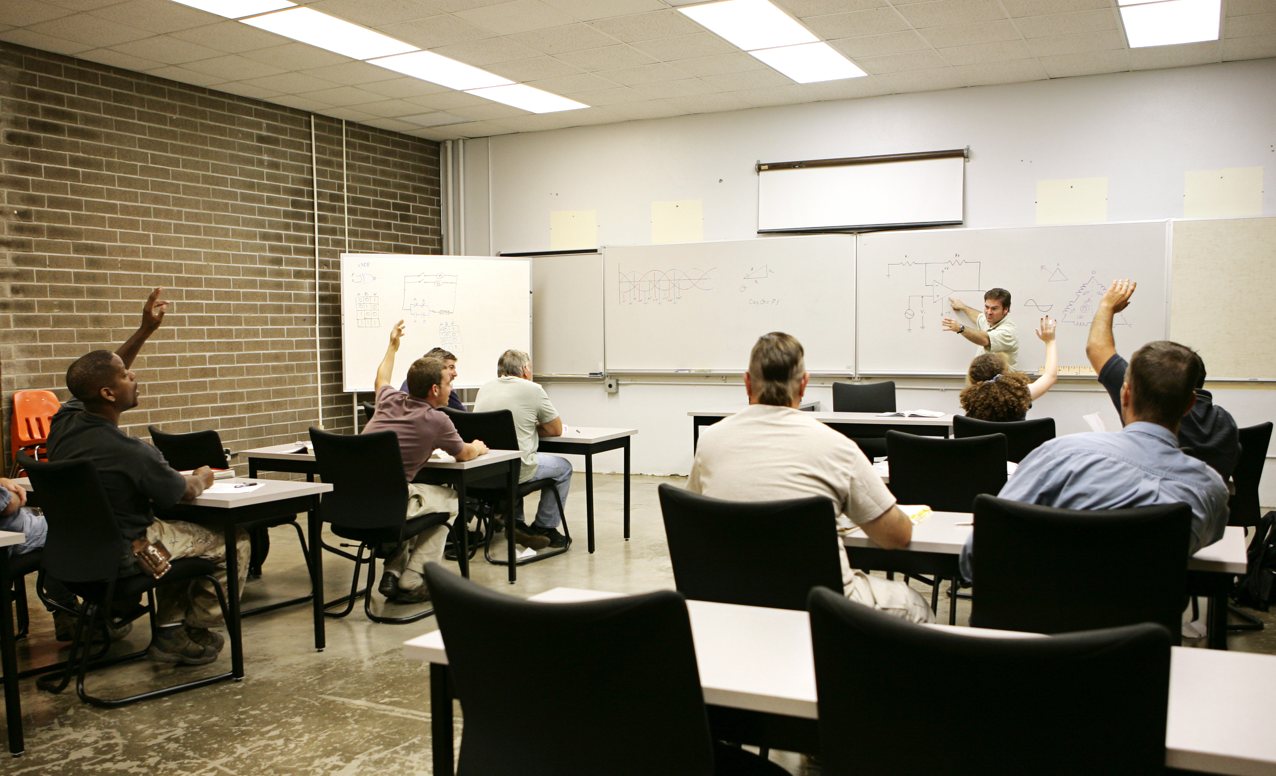 013482231_Adult education class raising their hands to answer a question..jpg