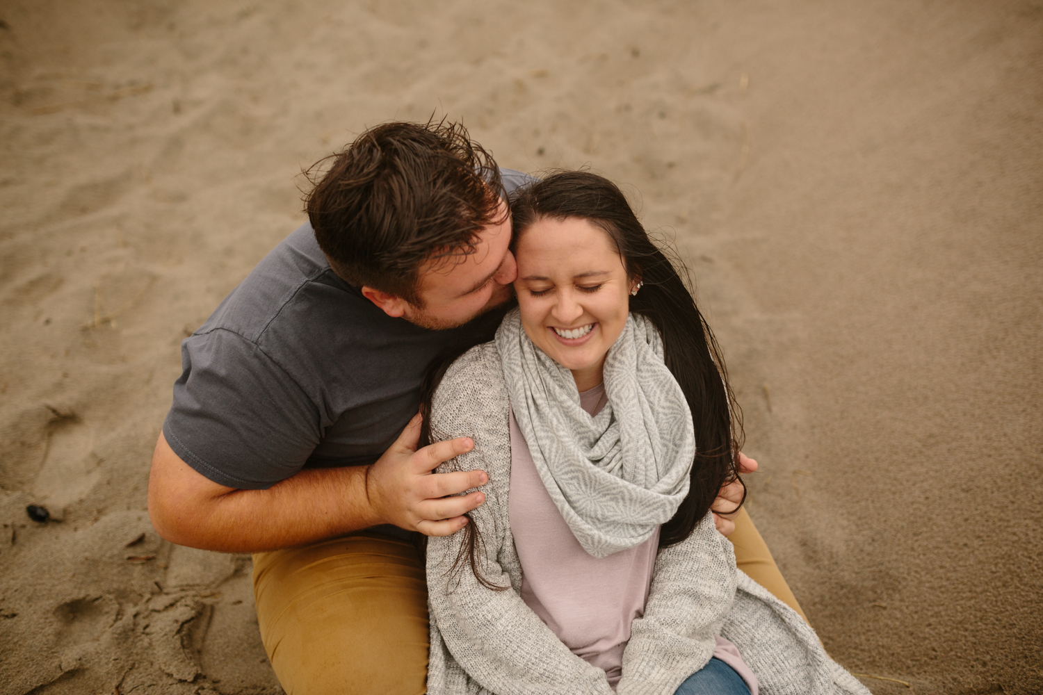 A happy couple cuddling on the sand