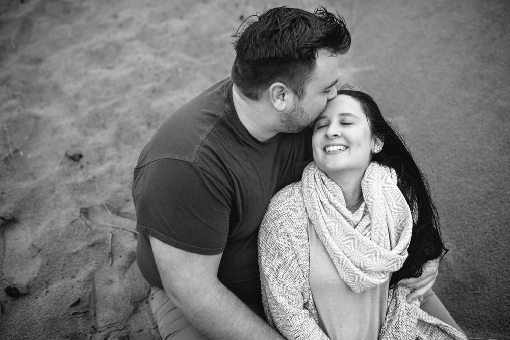 A happy couple cuddling on the sand