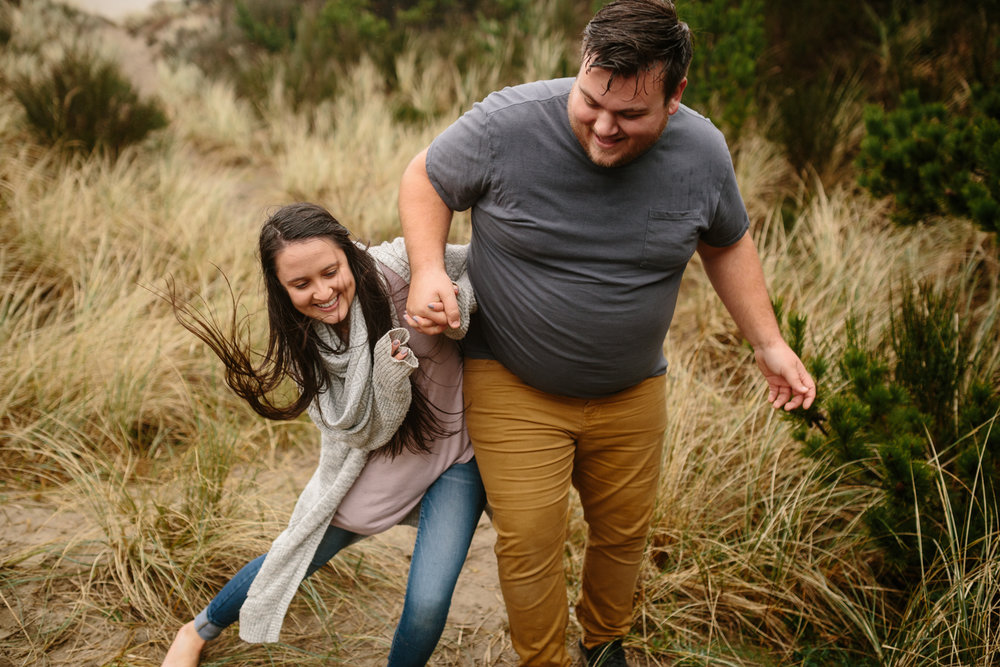 A happy, laughing young man and woman dancing and playing on the