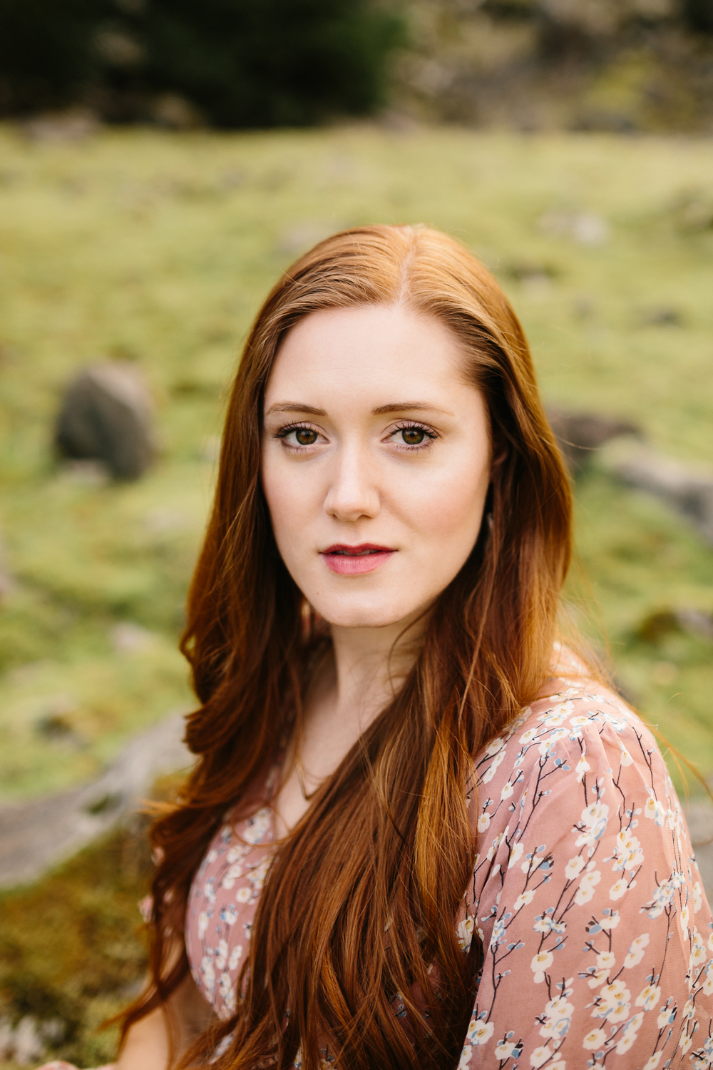 Portrait of a gorgeous red-headed woman with a mossy backdrop