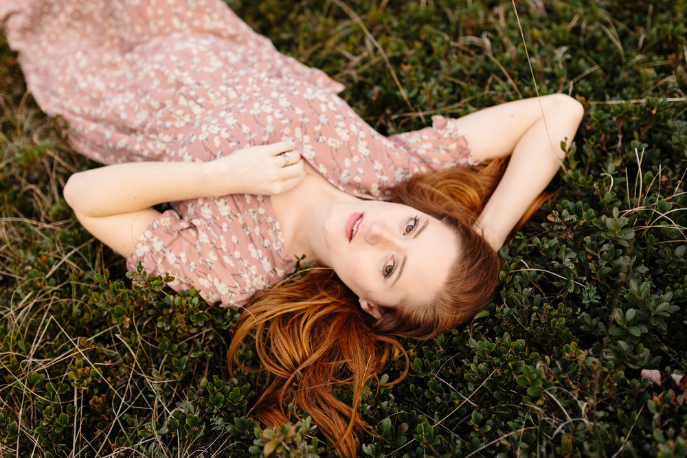 Portrait of a beautiful red-haired woman laying amidst succulent