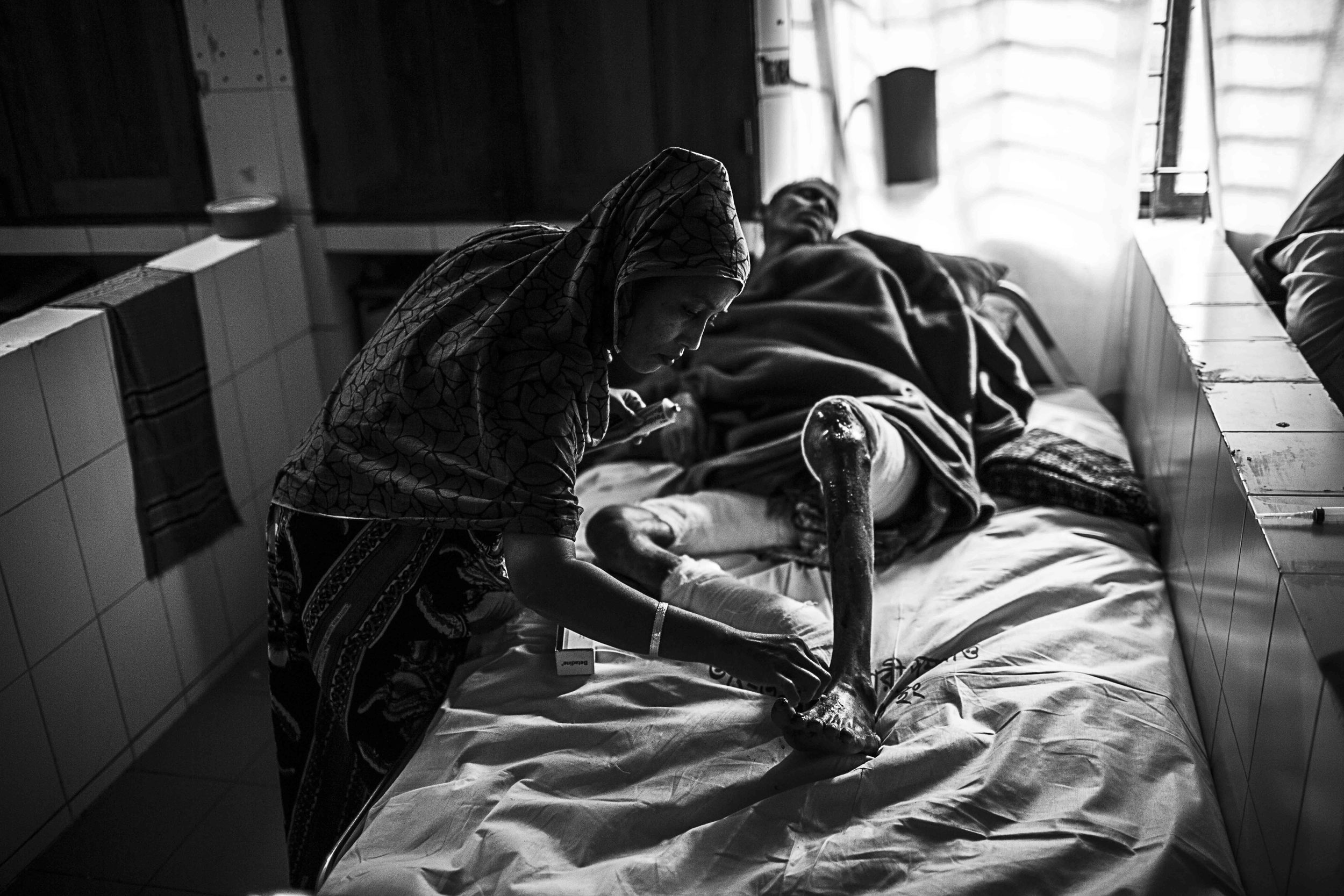  Nasima Begum tends to her husband, Mohammad. Some duties are left to family members instead of nurses.      