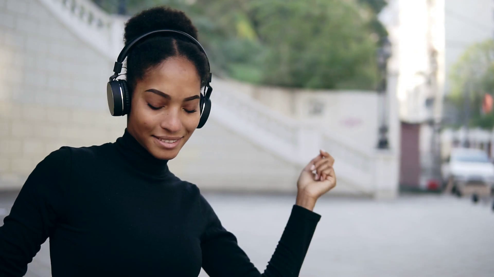 videoblocks-beautiful-afro-girl-happy-smiling-with-closed-eyes-stunning-african-woman-with-light-brown-skin-relaxing-in-headphones-and-slowly-dancing-bright-outdoors-background-wearing-black-sweater-slow_rvsvyxmzo_thumbnail-1080_01.png