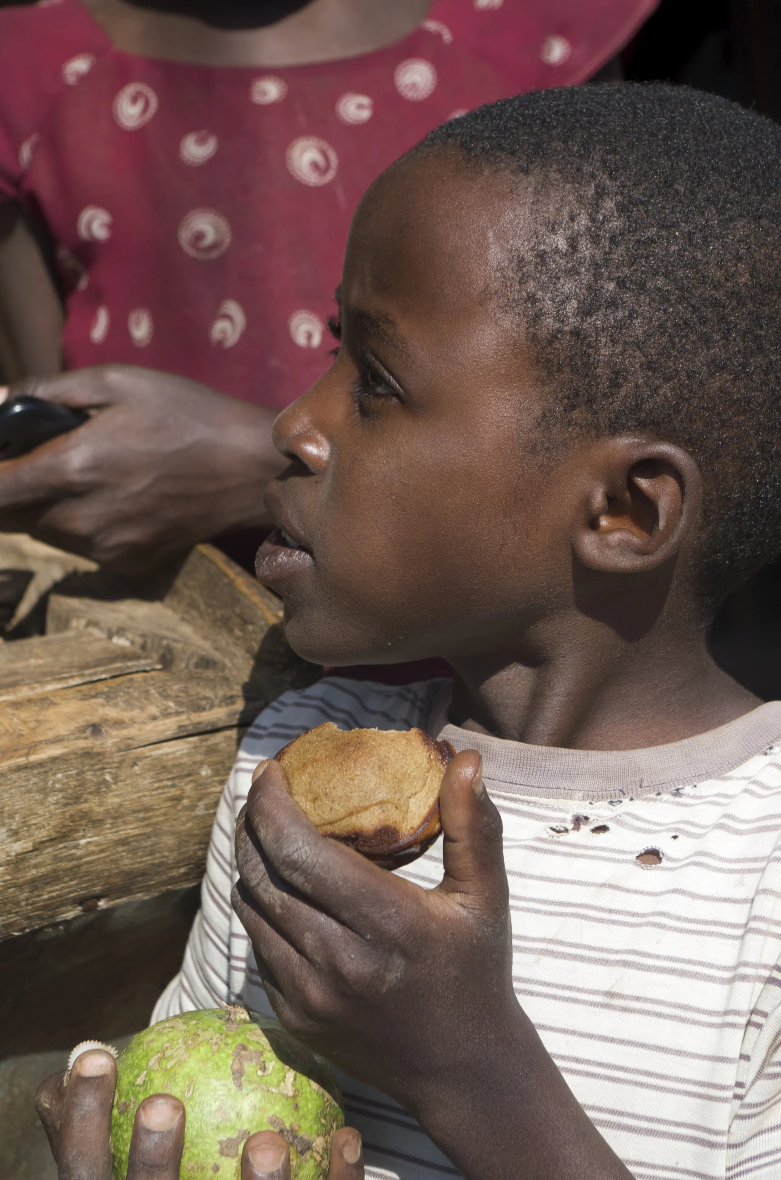 A local Kemondo resident gets a taste of the Women's Bakery newest banana recipe product.