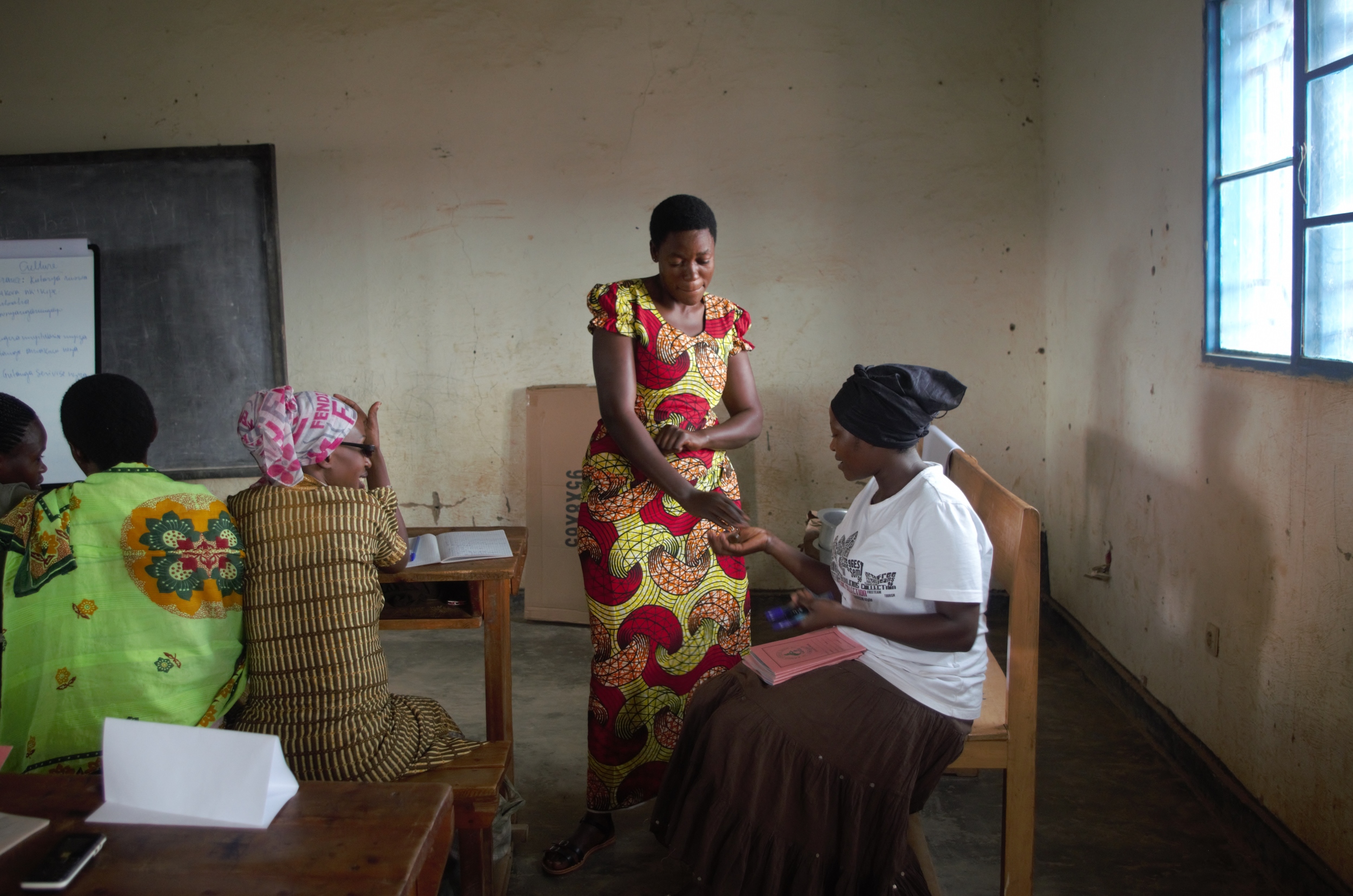 Jeanne D'Arc practicing the process of selling with fellow training participants in the Remera & Kanombe training group in Kigali.