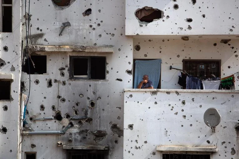 A man awaits Palestinian Prime Minister Rami Hamdallah in the Shijaiyah neighborhood of Gaza. Photo courtesy of Khalil Hamra/AP. 