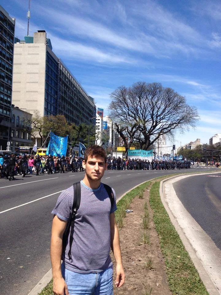 Adam stands in front of a labor protest, a common sight in Buenos Aires where the laborers and government often clash over economic policies.