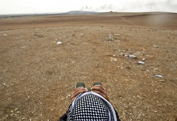 Man looks onto the Syrian town of Kobani, near the Turkish border, during US airstrikes to combat the Islamic State. Source: The AP