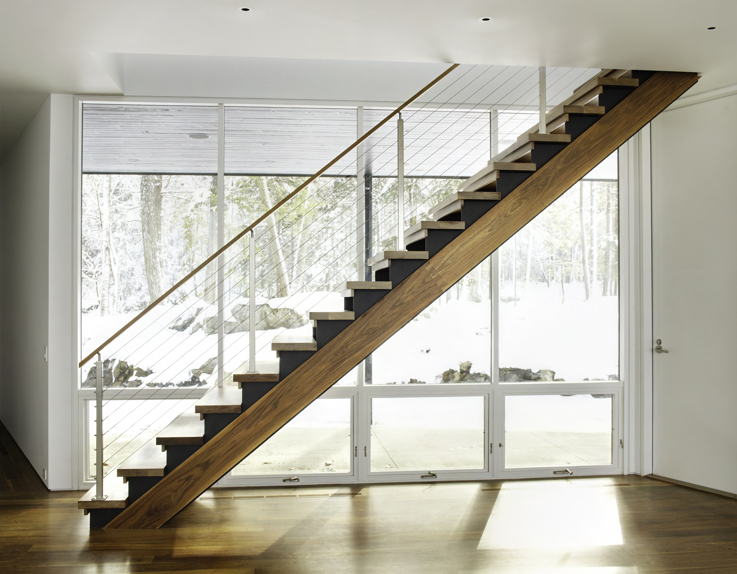 gorgeous wooden staircase and large glass windows panoramic forest views