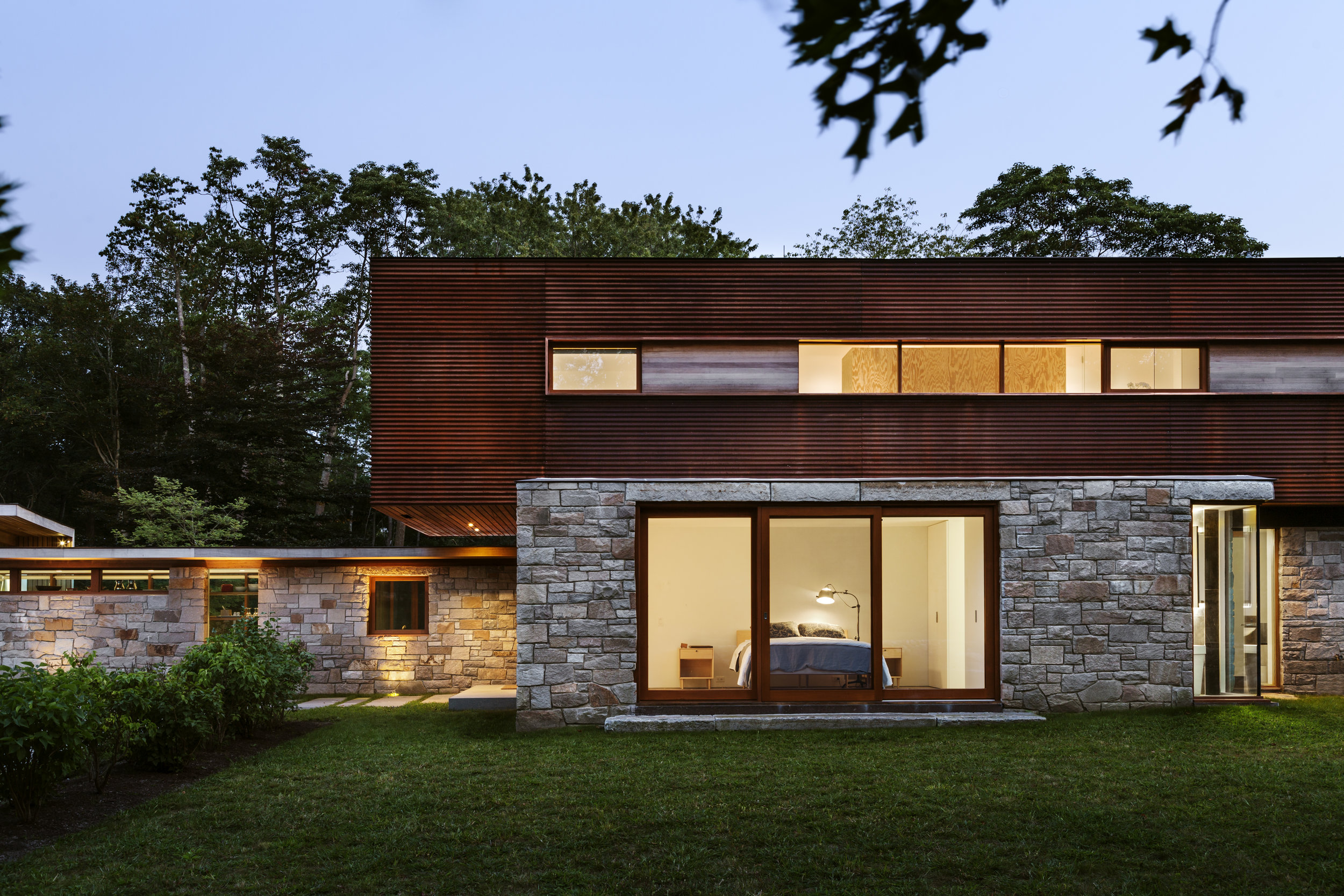 large glass windows with stone veneer and wood architecture