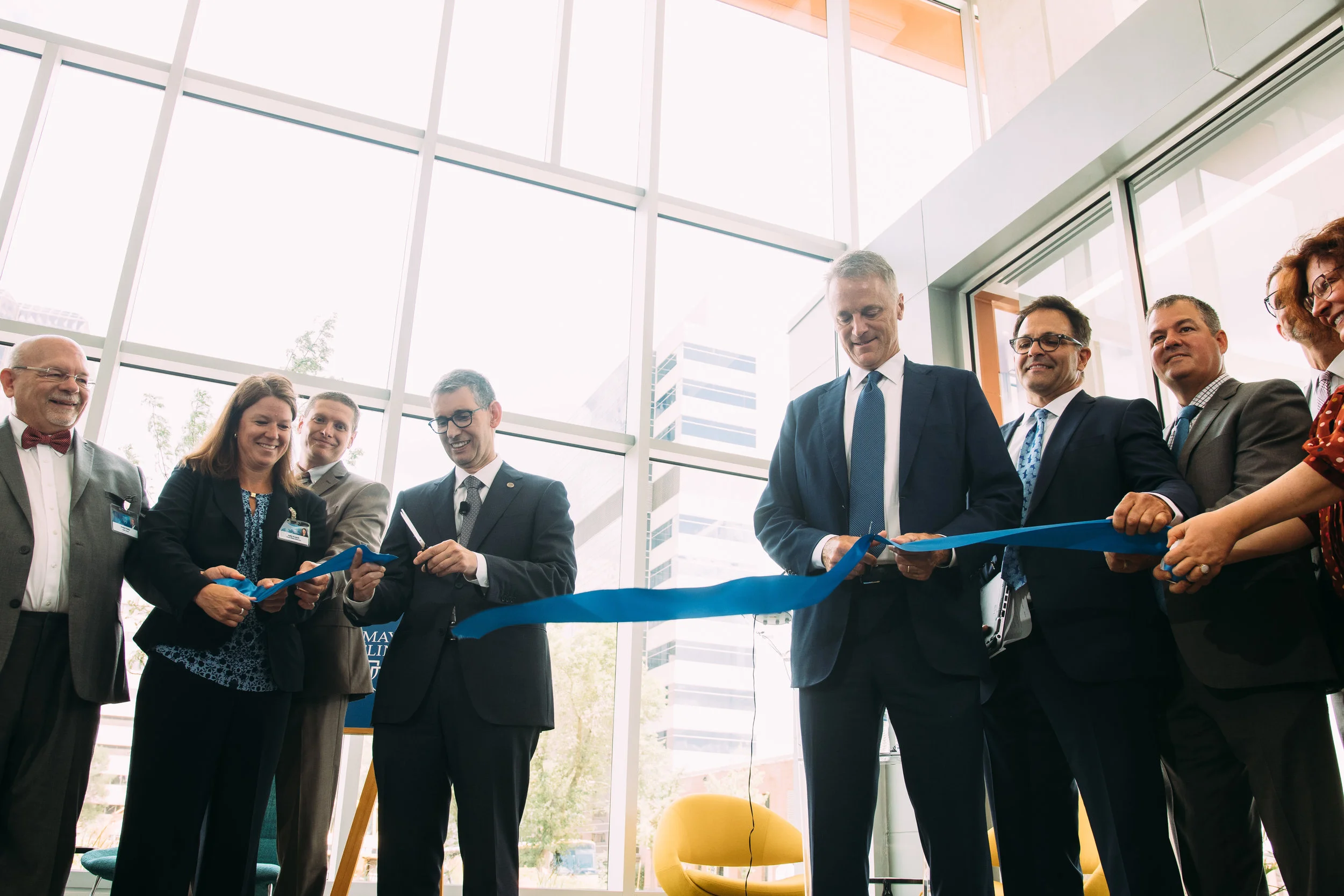 Farrugia (center left) and Mahoney (center right) join in a ribbon cutting Monday at One Discovery Square in downtown Rochester.