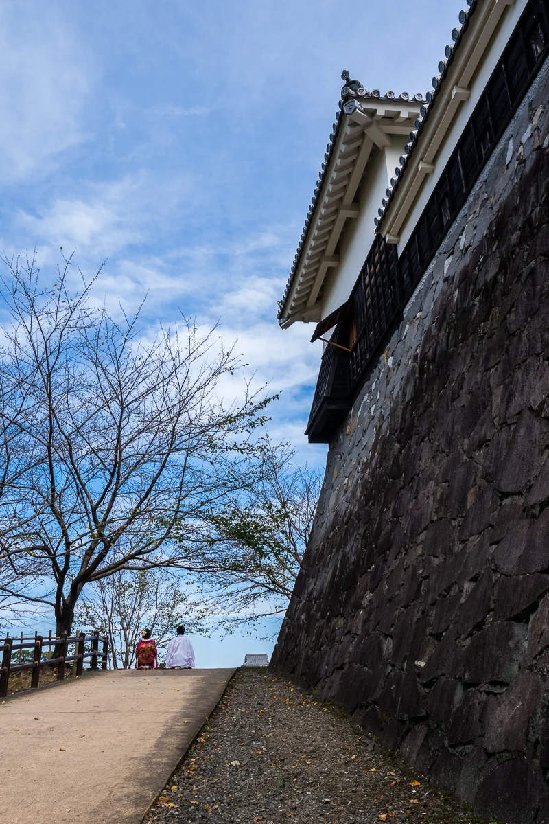 運氣好剛好遇見兩位日本新人著傳統禮服拍婚紗，我躲在後面下坡處避開攝影師把我入鏡。新人與熊本城高聳圍牆相呼應，整個給它古色又古香！