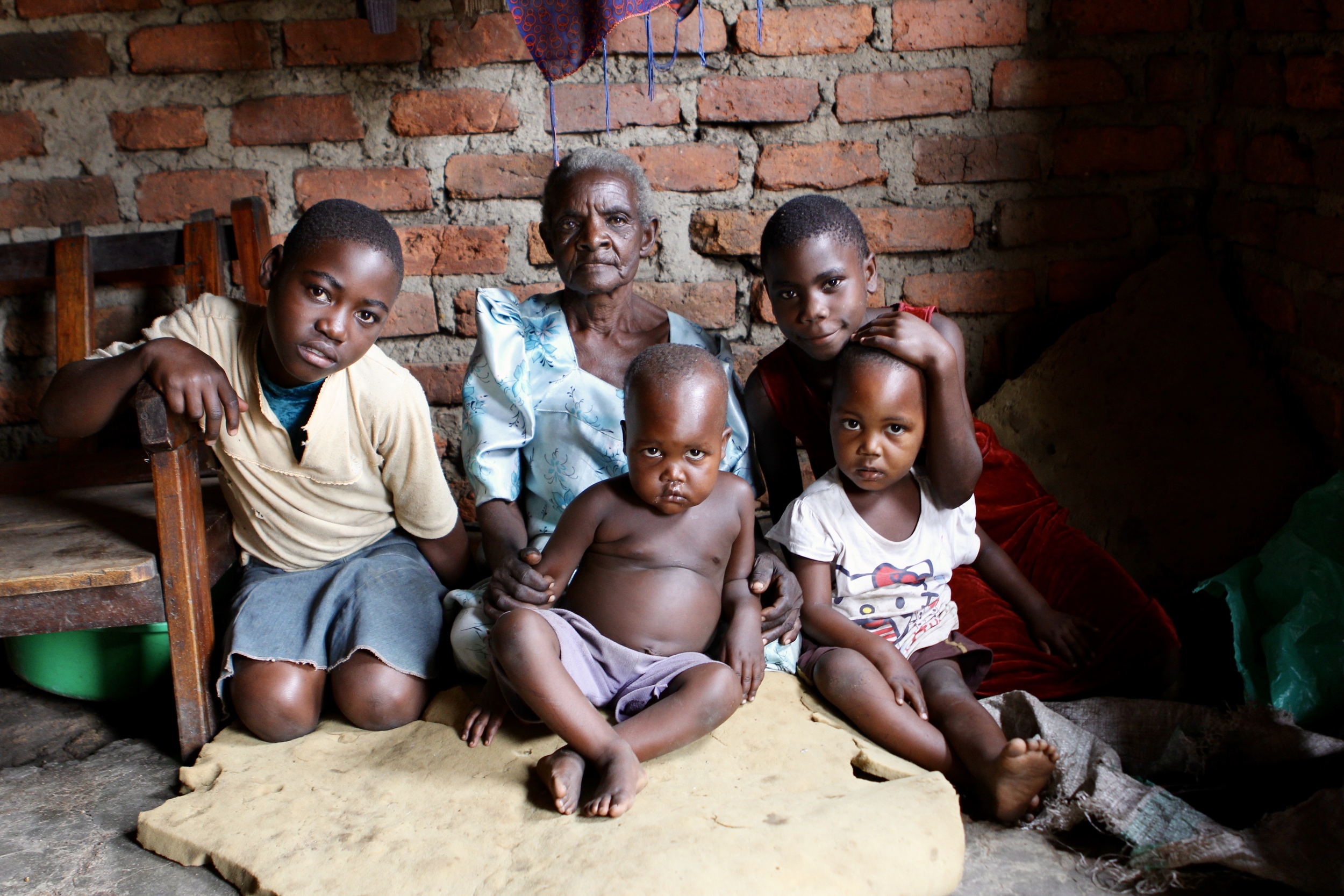 This Jaja (grandmother) is in her 90's and raises 6 of her grandchildren in her home. Some of the staff at Cherish heard about her situation and so one of our girl's homes began visiting her on weekends to help her with her chores. Her granddaughter (pictured in the red dress) attends Cherish Primary School and Charles is now working with the grandma to help her increase her income so that she can provide for these children. 