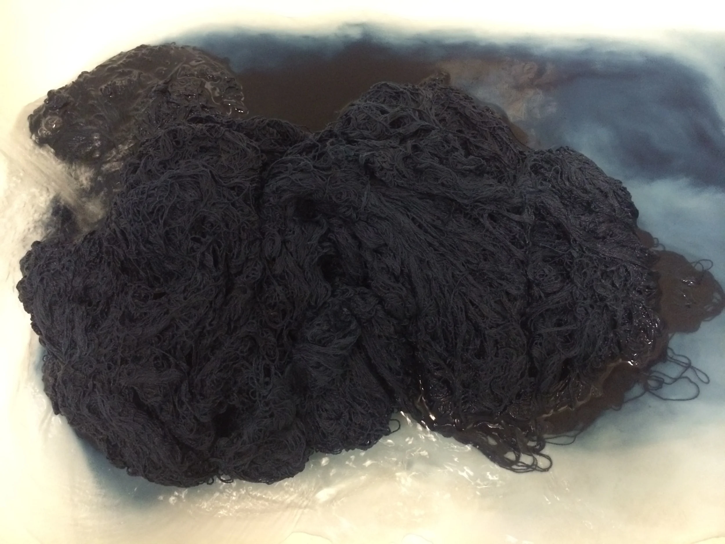Rinsing the yarn three times to wash out the excess dye. The yarn still stays a surprisingly deep hue of blue. Eventually, we'd like to reach a point where the extra washes and rinses wouldn't be necessary. For now, it's a learning process. 