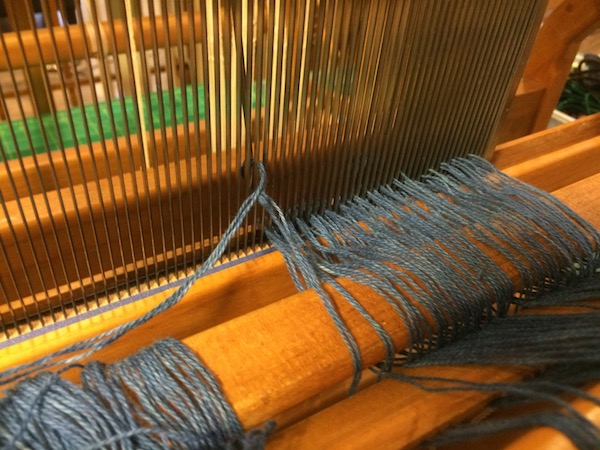  Our hand dyed indigo yarn being pulled through the reed.&nbsp; 